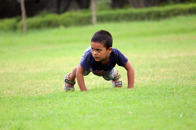 Boy doing pushup. Encourage your child with autism and ADHD to exercise.