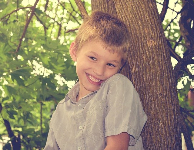 Boy standing next to a tree. Do you need a special needs trust fund for your autistic child?