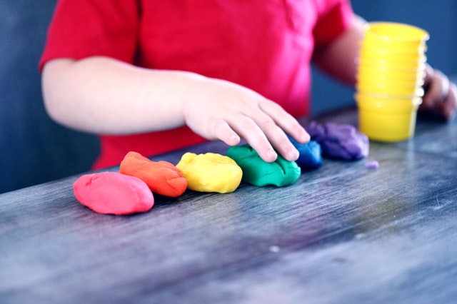 Child playing with clay. Find childcare for your child with autism.