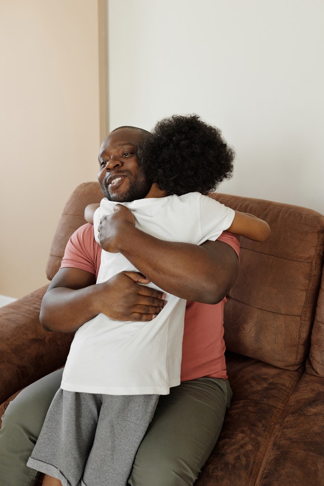 Dad hugging boy. Help your child through autistic burnout and emotional exhaustion.