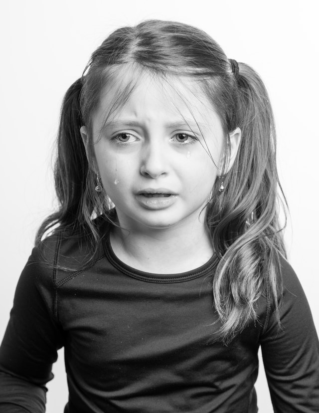 Girl with tear in her eye. Helping your child with autistic burnout and emotional exhaustion.