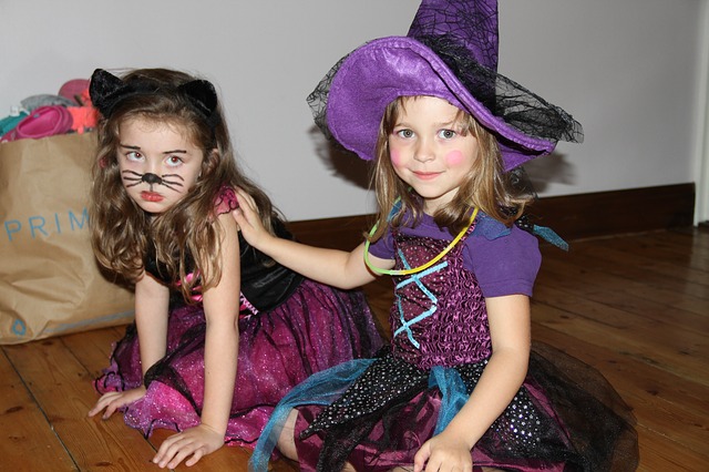 Two little girls in witch costume. Halloween for autism.