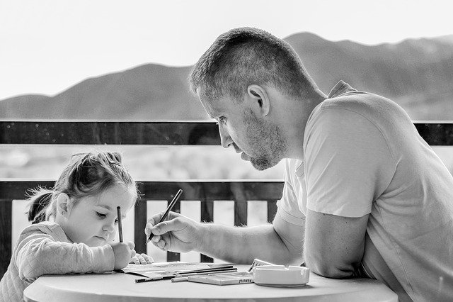 Dad sitting with his daughter. How do autism parents deal with judgement?