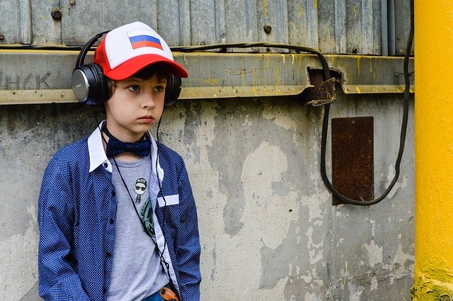 Boy standing with headphones on. How to protect your child with autism from bullying.