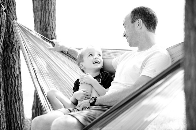 Father and son sitting in hammock. Financial planning for families with autistic child.