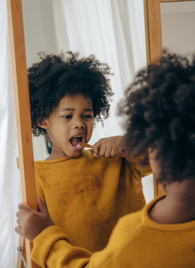 Girl brushing teeth. Would a token system help your child with autism and ADHD?