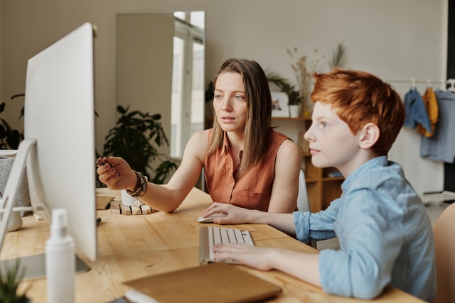 Mom looking at computer with son. How to advocate for your autistic child?