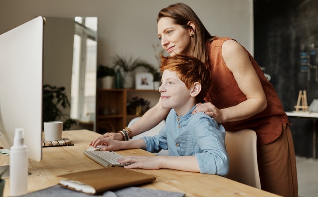 Mom and teen boy on the computer. Ensure Internet safey for teenager with autism.