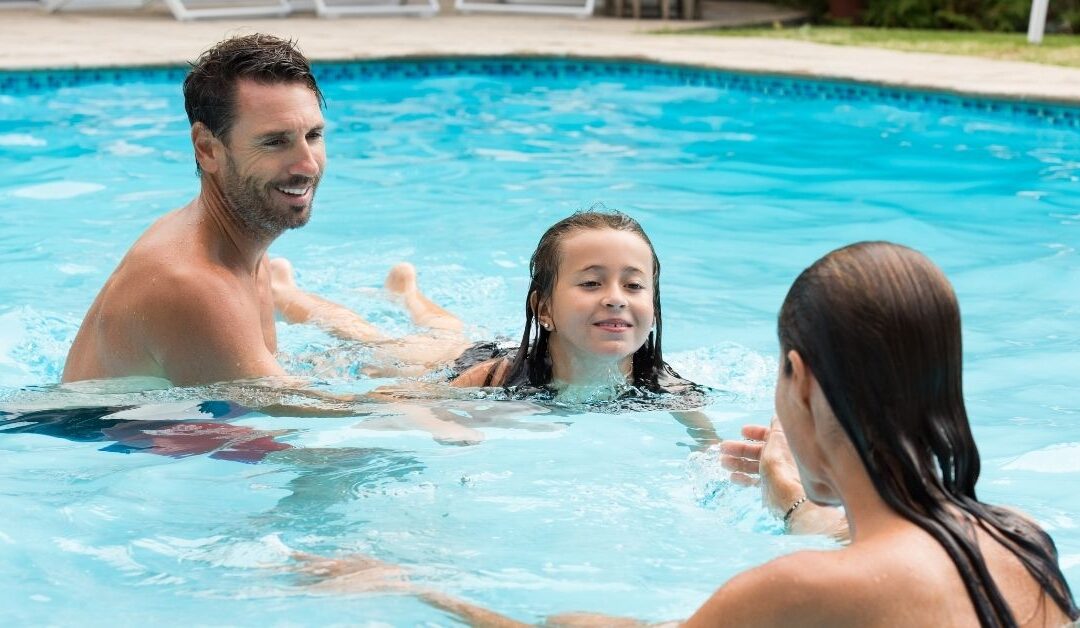 Parents helping their little girl swim.