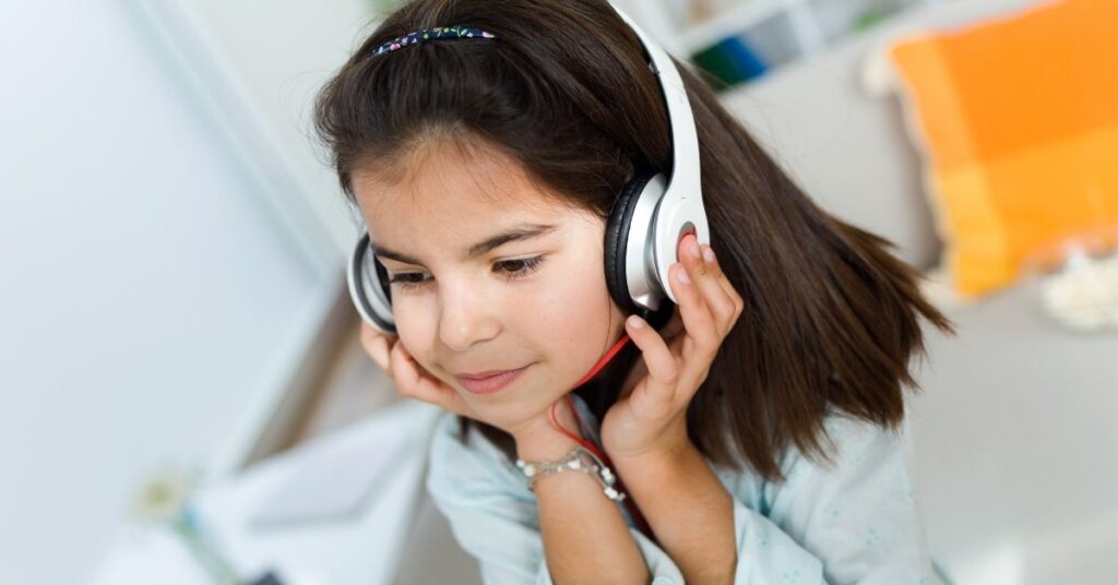 Girl wearing headphones and listening to music. How music benefits your autistic child.