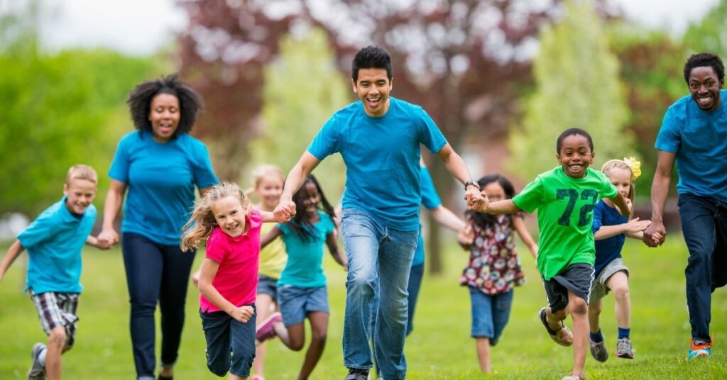 Camp counselors and kids running. Summer camp can benefit children with autism.