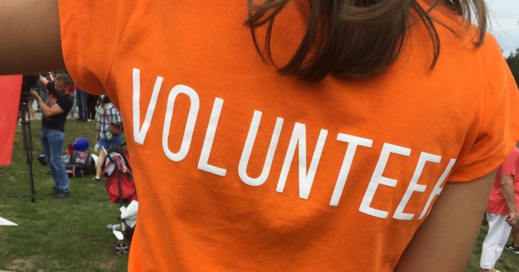 Orange T-shirt with "VOLUNTEER" written across the back. How volunteering can help teenagers with autism and ADHD.