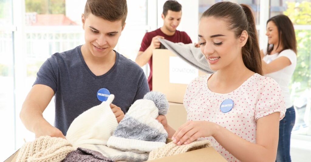 Teenage boy and girl sorting clothes. How volunteering can help teenagers with autism and ADHD.