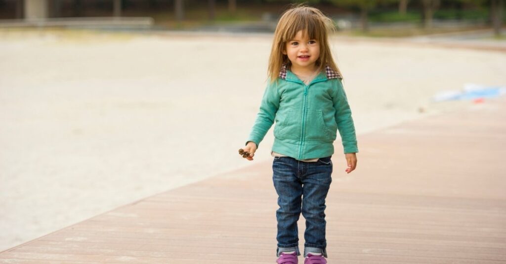 Little girl standing. Does a speech delay always signal autism in children?