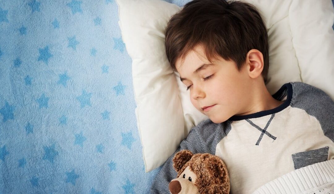 Boy sleeping with teddy bear.