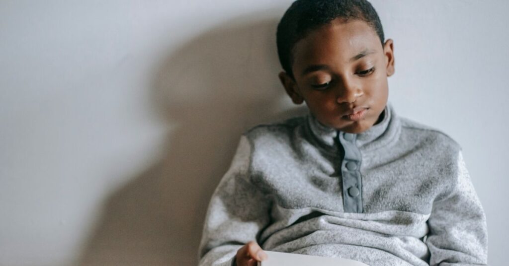 Boy sitting against a wall. What is pathological demand avoidance?