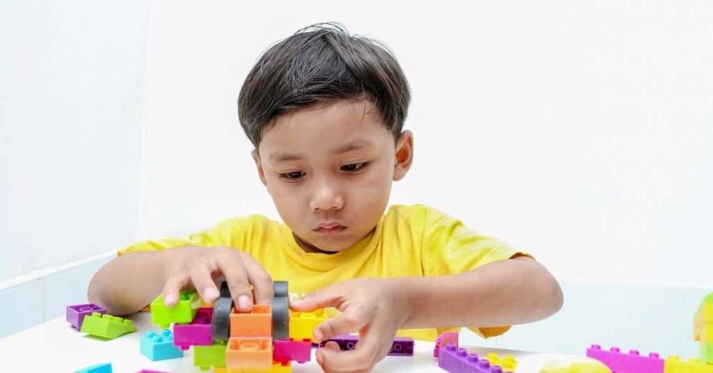 Boy playing with blocks. Could your autistic and ADHD child also have alexithymia?