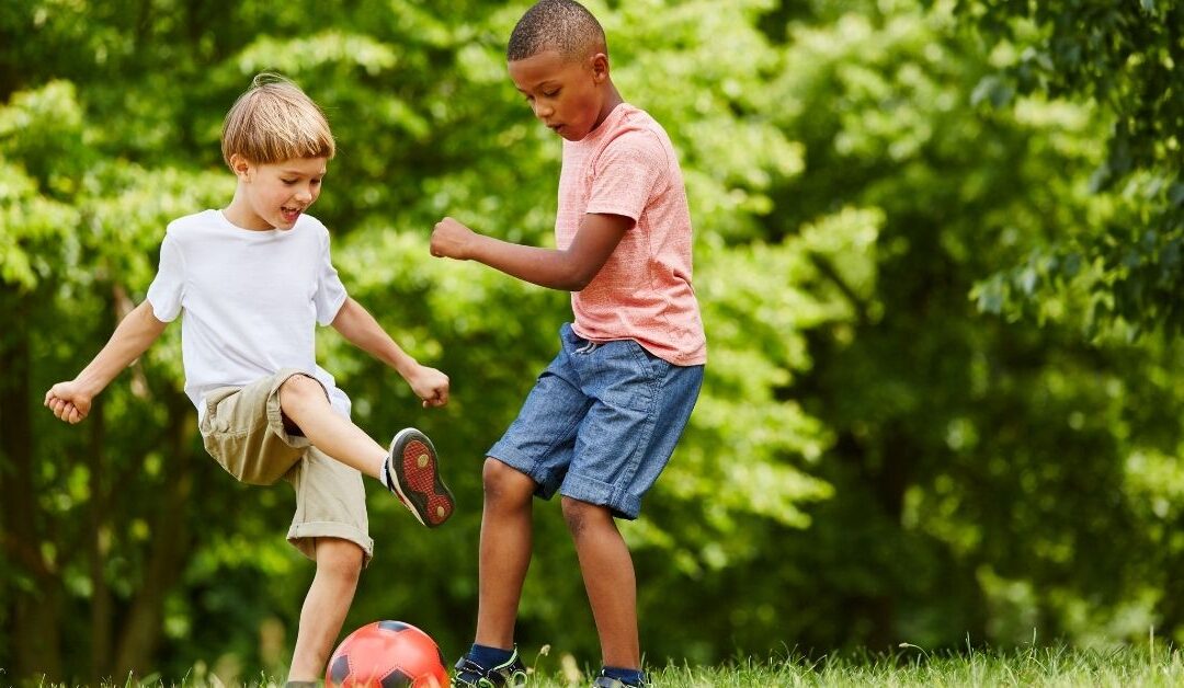 Two boys playing with a soccer ball.