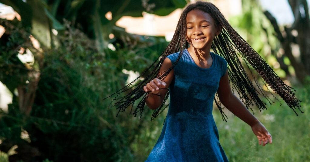 Black girl twirling. Should you encourage or discourage your autistic child's stimming?