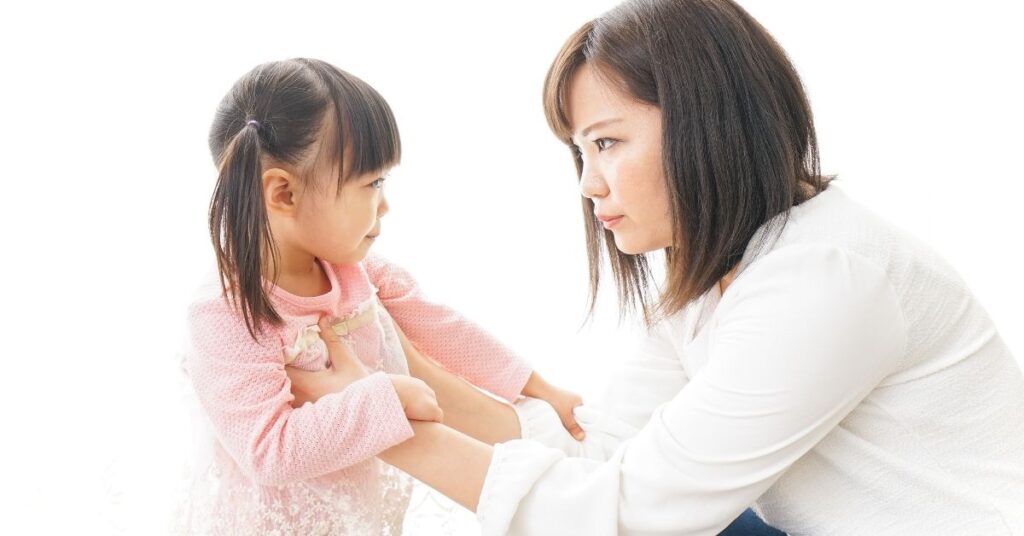 Mom looking sternly at young daughter. How can you have a more positive mindset about your child's autism?