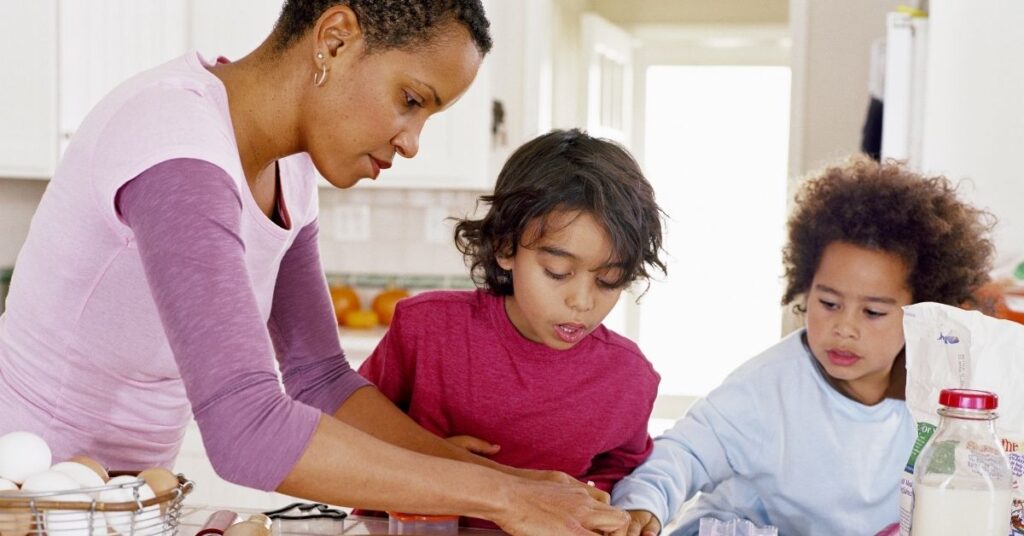 Mom with two boys in the kitchen, making cookies. What to do if you think your friend's child may have autism.