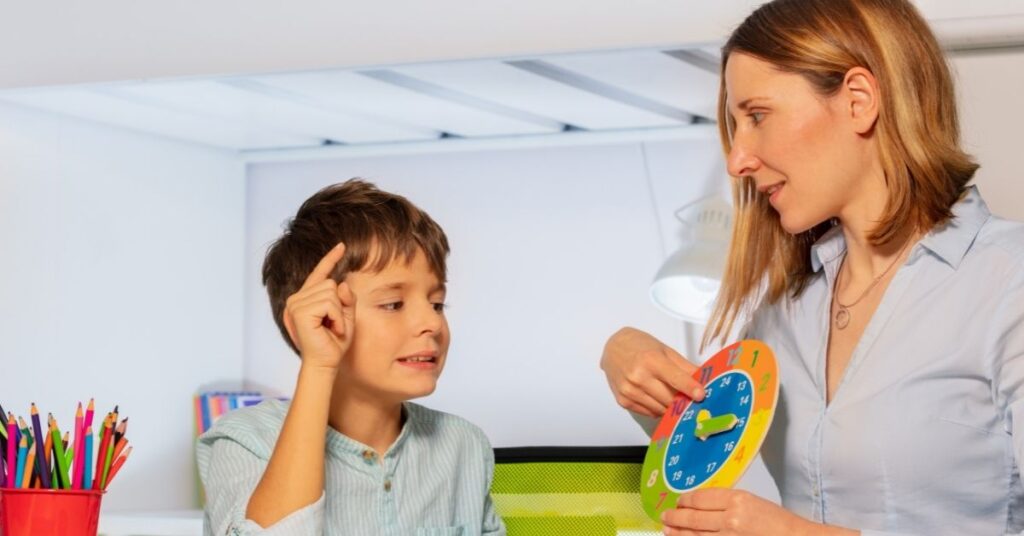 Speech therapist holding a clock and working with boy. Which treatments are the best for your child with autism and ADHD?