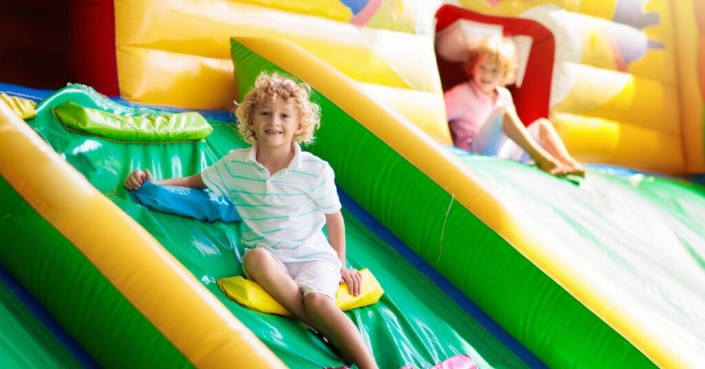 Boy sitting on bouncy slide