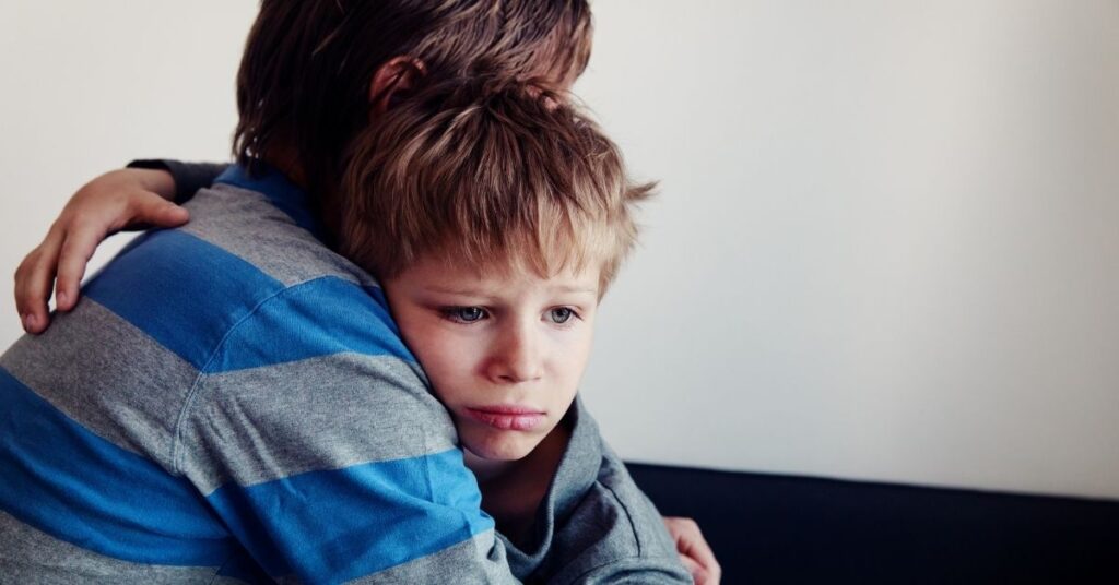 Mom holding young son. How can you prevent your autistic child from self-harm?