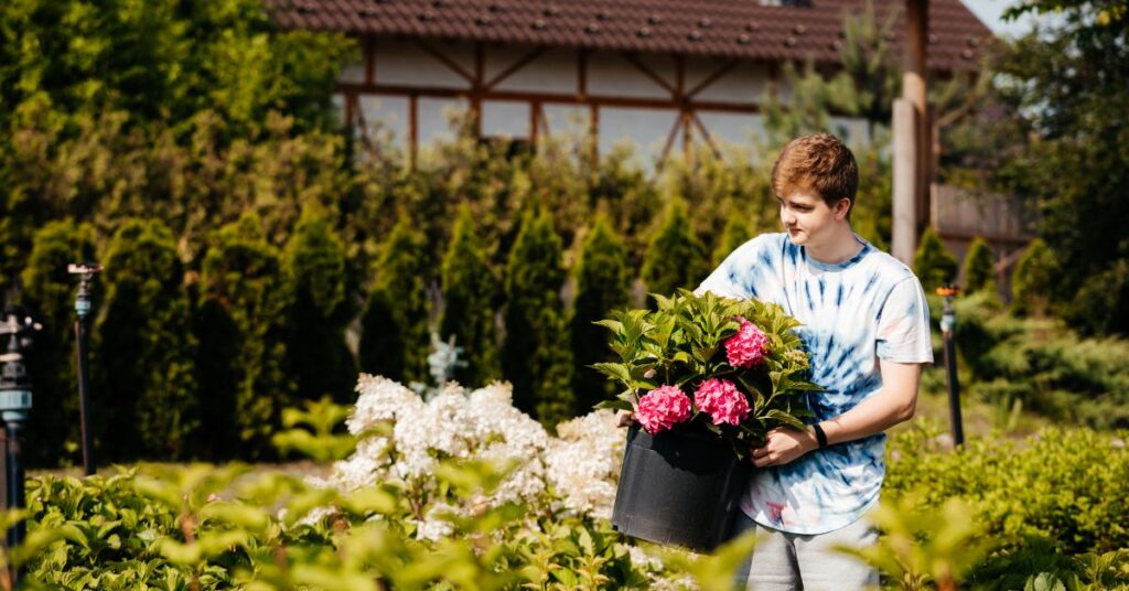Teenage boy working at a plant nursery. Should your autistic teenager work with a job coach for their first part-time job?
