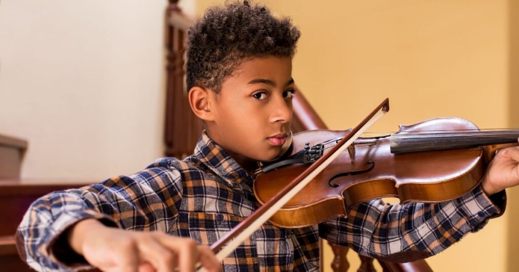 Boy playing violin. How can you support your child with autism's special interest?