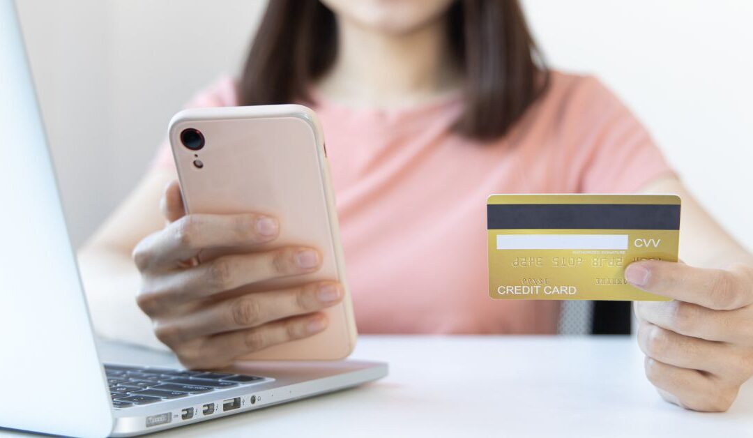 Teen girl holding a phone and credit card