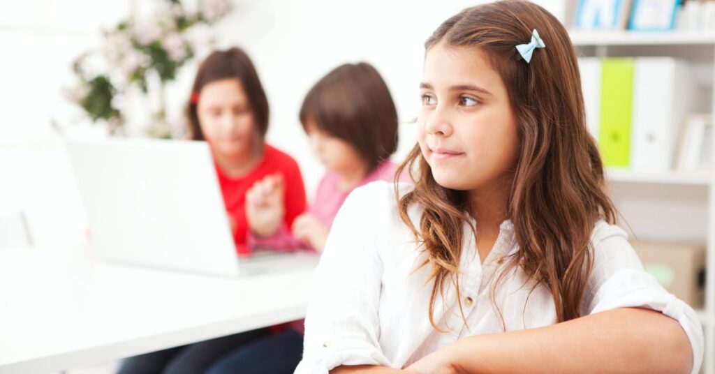 Girl sitting in classroom. Learn how to enforce the IEP developed for your autistic child.