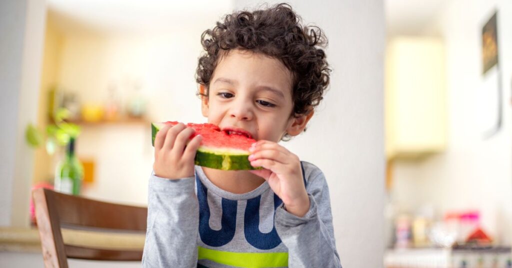 Boy eating a big watermelon slice