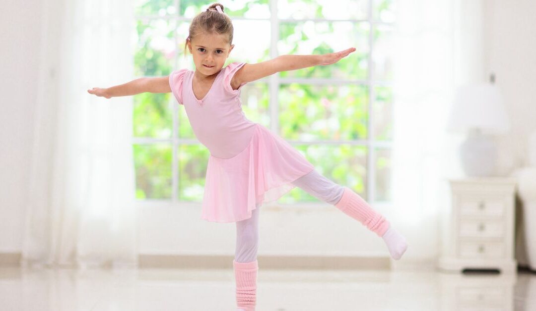 Little girl in pink dancing clothes doing a dance move