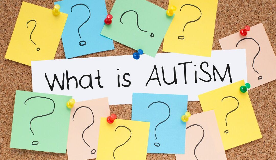 Post-it notes with question marks around "What Is Autism" on bulletin board