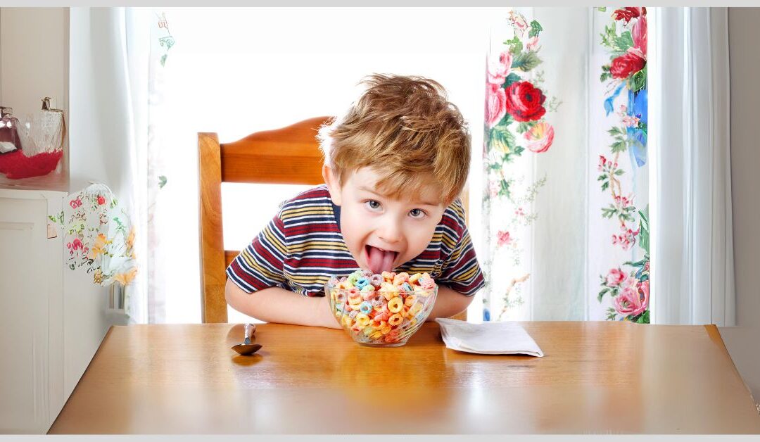 Boy licking at big bowl of sugary cereal