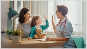 Mom holding girl, who is giving a high five to a healthcare professional. How do you find a good healthcare professional for your child with autism?