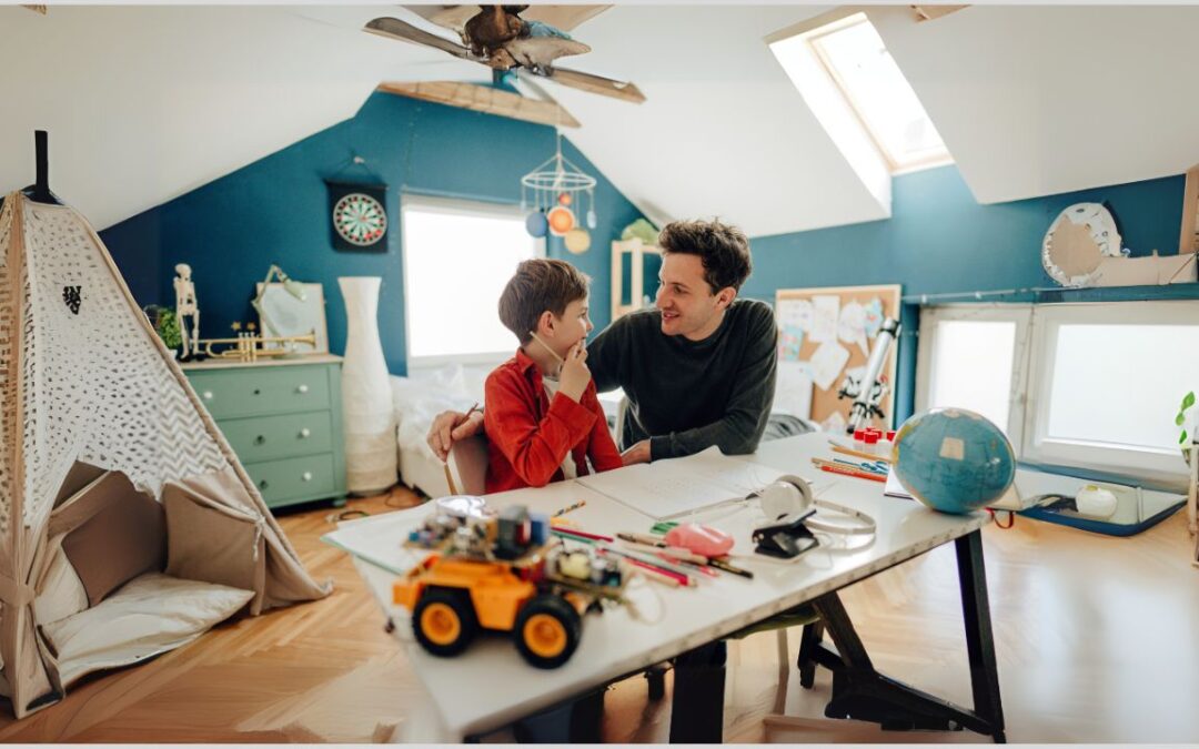 Dad sitting at a desk with his son while he does schoolwork