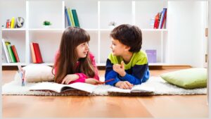 Boy and girl laying on rug with pillows and talking. Appreciate the positive aspects of your autistic child's thinking and ideas.